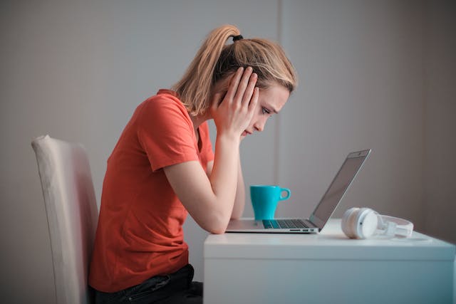 A person looking stressed at a laptop