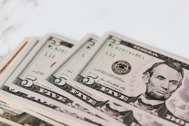 Several American five dollar bills.